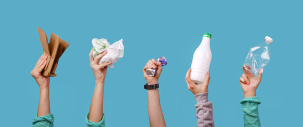 Hands holding bottlesm packages for recycling